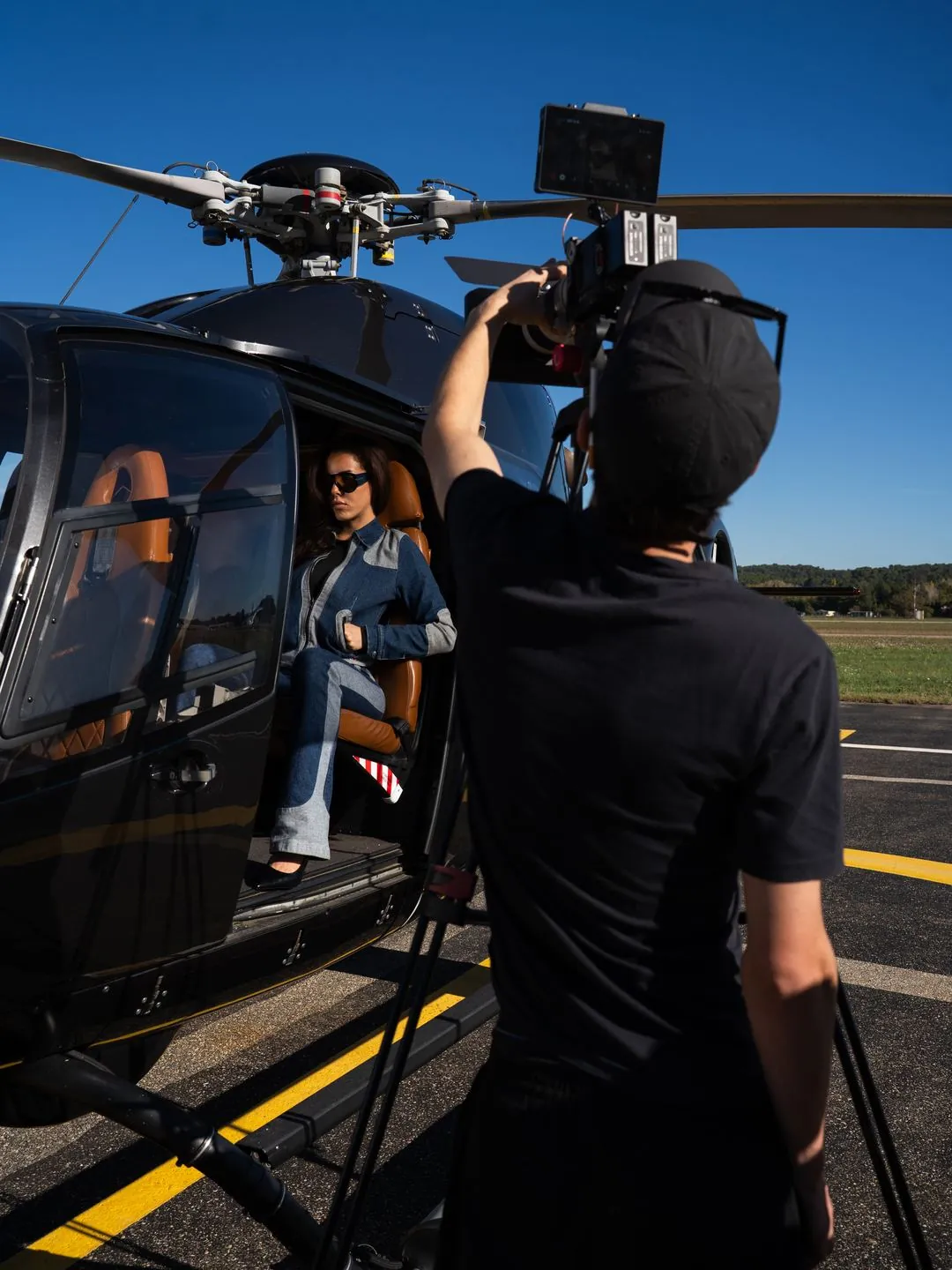 Caméra à l’épaule sur un tournage, devant un hélicoptère